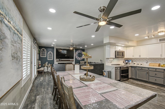 dining space with dark wood-style floors, visible vents, and recessed lighting