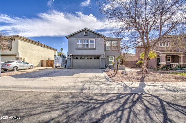 view of front facade featuring an attached garage, driveway, fence, and stucco siding