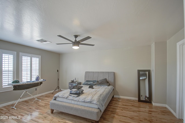 bedroom featuring baseboards, visible vents, and light wood-style floors