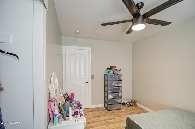 bedroom featuring light wood-type flooring, a ceiling fan, and baseboards