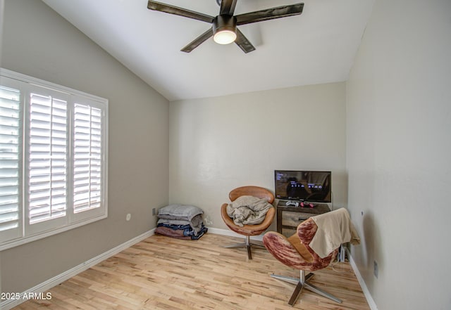 sitting room featuring a ceiling fan, baseboards, vaulted ceiling, and wood finished floors