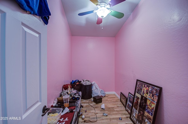 interior space with ceiling fan, wood finished floors, and baseboards