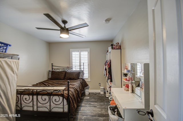 bedroom with ceiling fan, dark wood-style flooring, and baseboards