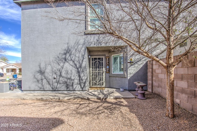 exterior space featuring fence and stucco siding