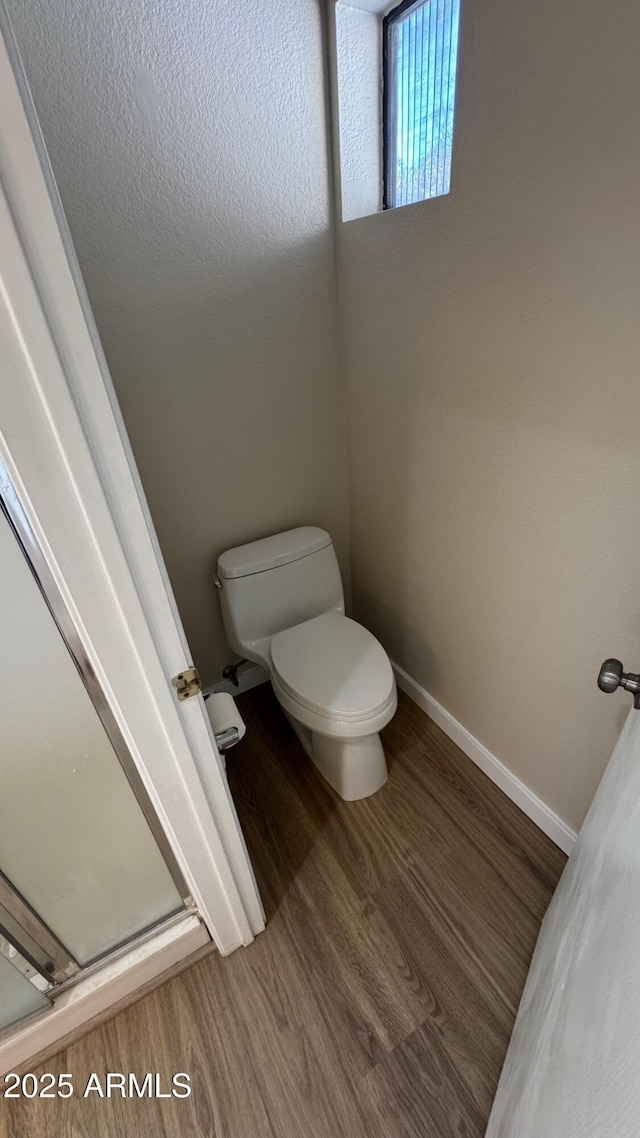 bathroom with toilet and hardwood / wood-style floors