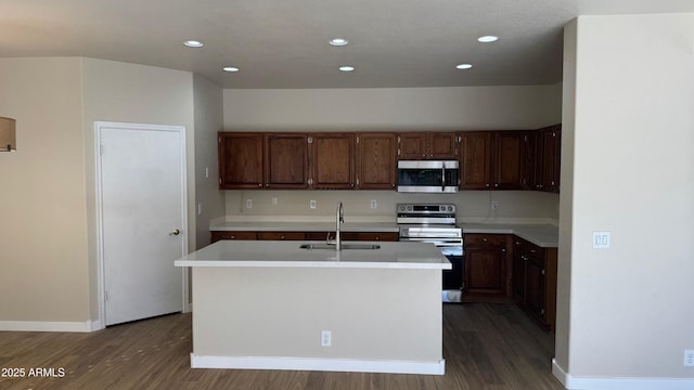 kitchen featuring sink, a center island with sink, hardwood / wood-style flooring, and appliances with stainless steel finishes