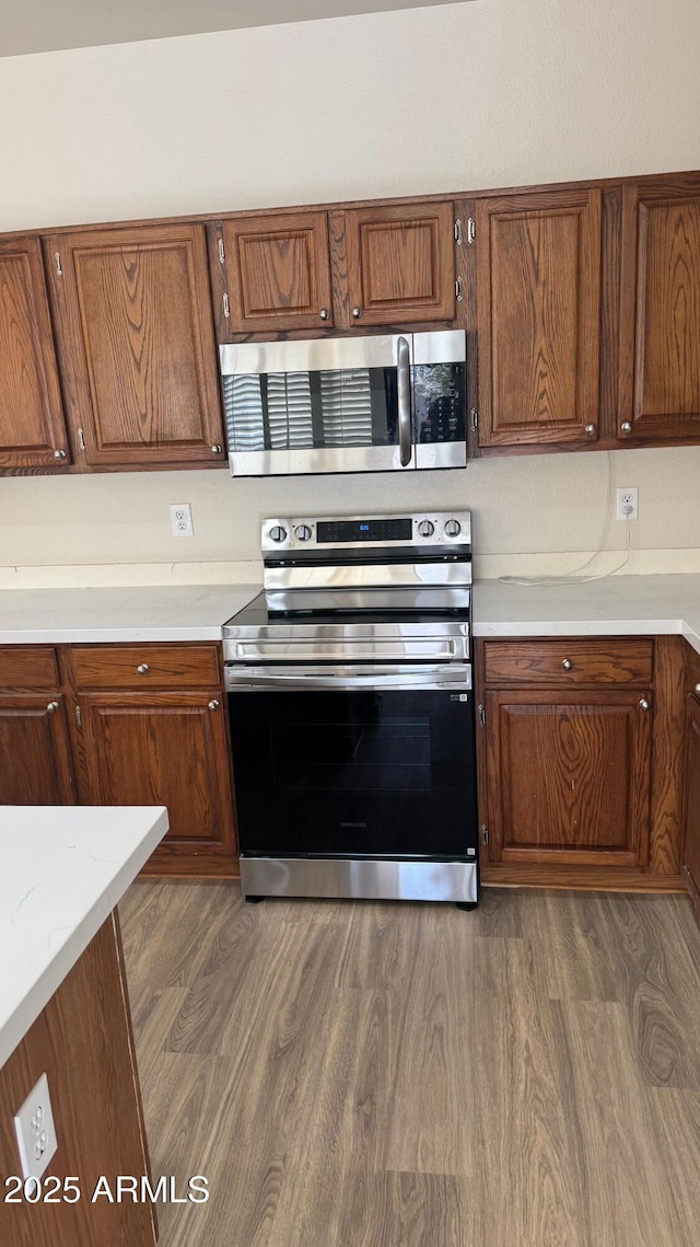 kitchen featuring appliances with stainless steel finishes and dark hardwood / wood-style floors