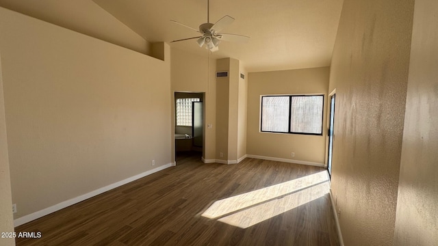 spare room with lofted ceiling, dark wood-type flooring, ceiling fan, and a wealth of natural light