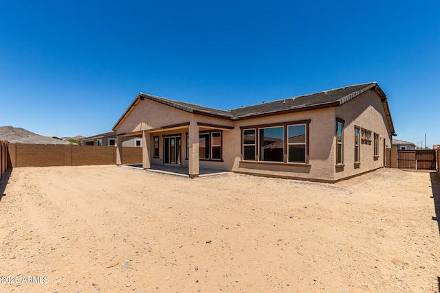 20273 W Monterey Way, Buckeye, AZ 85396 - back of property with stucco siding, a fenced backyard, and a patio