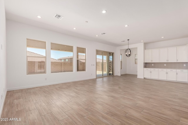 20273 W Monterey Way, Buckeye, AZ 85396 - unfurnished living room featuring recessed lighting, light wood-type flooring, and a chandelier