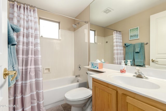 bathroom featuring vanity, shower / bath combination with curtain, visible vents, and a healthy amount of sunlight