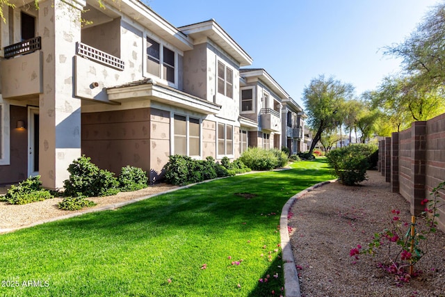 view of community featuring a yard, fence, and a residential view