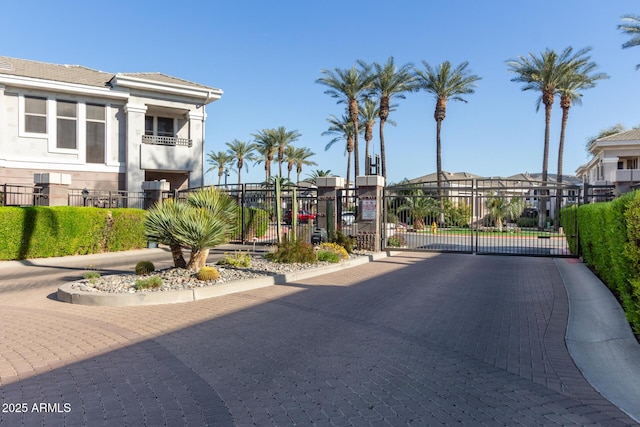 view of road featuring a residential view, a gate, a gated entry, and curbs