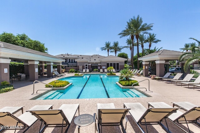 pool with a patio area and fence