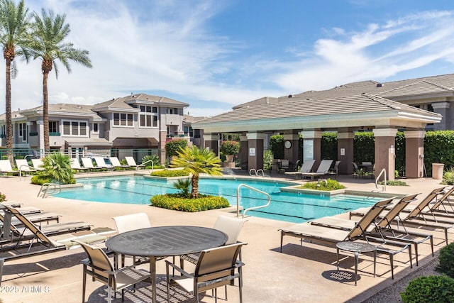 community pool with a patio area, fence, and a gazebo