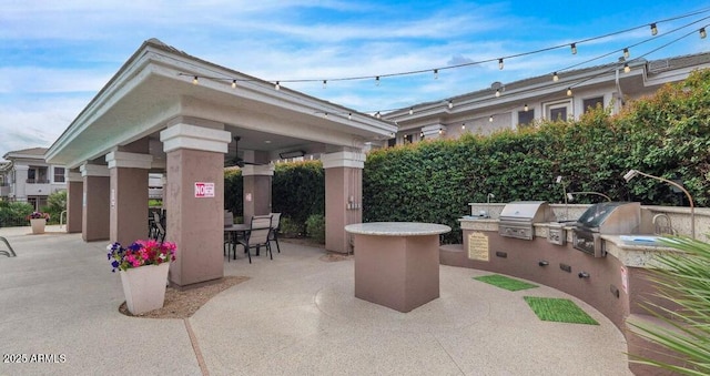 view of patio / terrace with a gazebo, a bar, an outdoor kitchen, and a grill