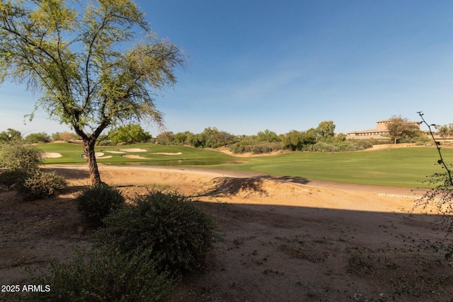 view of home's community featuring view of golf course and a yard