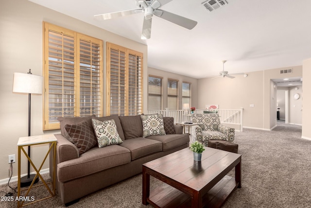 living room with carpet floors, visible vents, baseboards, and a ceiling fan