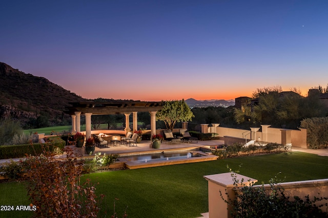 exterior space featuring a lawn, a mountain view, a pergola, a pool with hot tub, and a patio