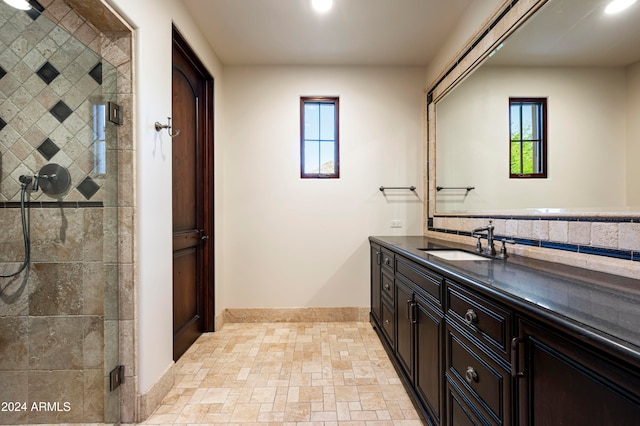 bathroom featuring a wealth of natural light, vanity, and a shower with shower door