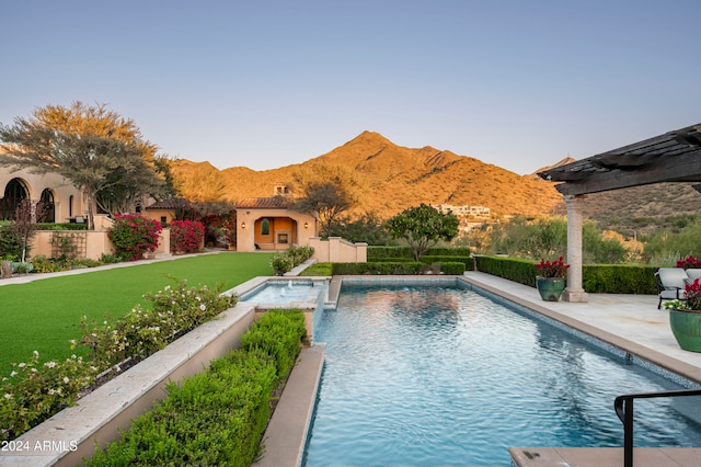 view of swimming pool with a mountain view, a patio, and a lawn