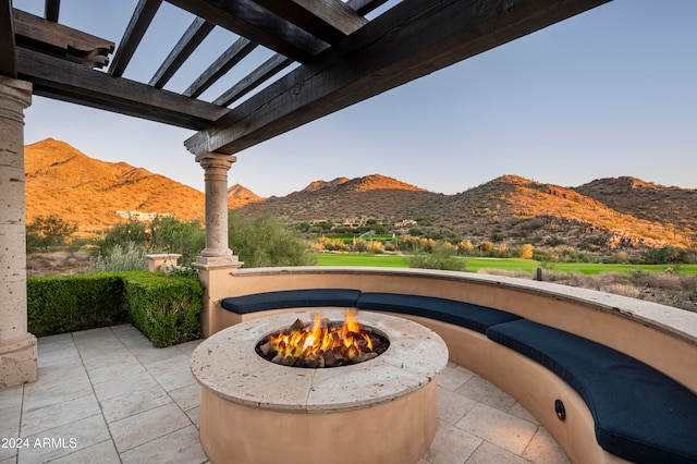 view of patio with a fire pit and a mountain view