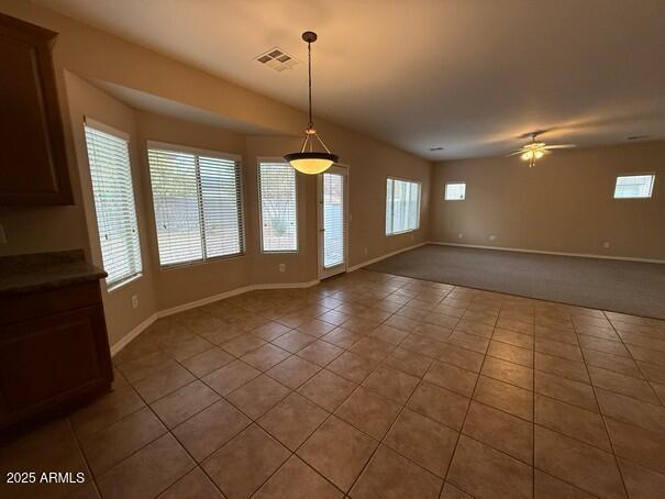 unfurnished dining area with ceiling fan and light tile patterned floors