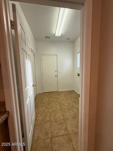 hall featuring light tile patterned floors