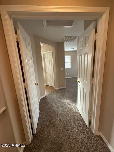 hallway featuring dark colored carpet