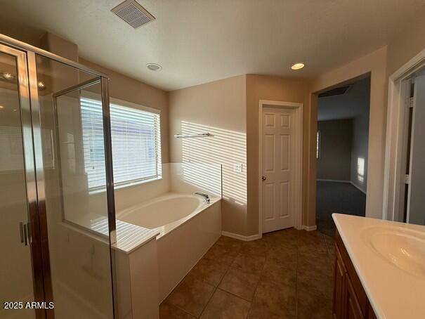 bathroom featuring vanity, shower with separate bathtub, and tile patterned flooring