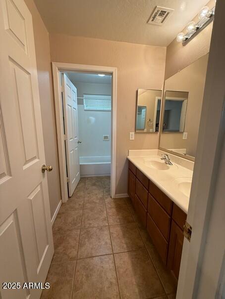 bathroom with vanity, tile patterned floors, and a tub to relax in