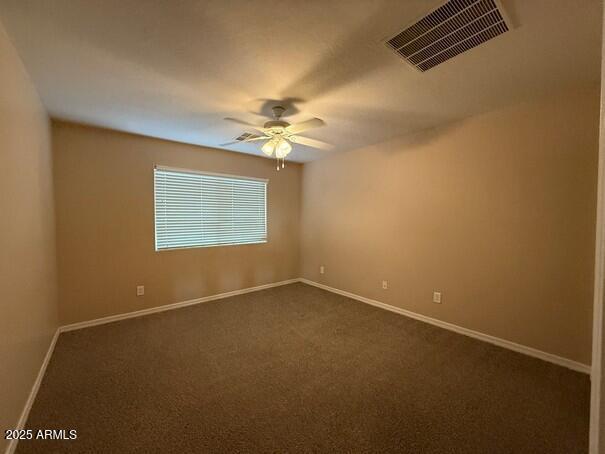 spare room featuring carpet floors and ceiling fan