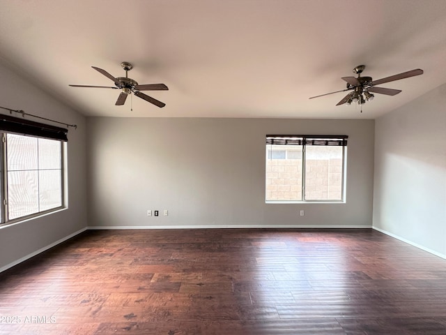 unfurnished room with ceiling fan, a healthy amount of sunlight, and dark hardwood / wood-style flooring