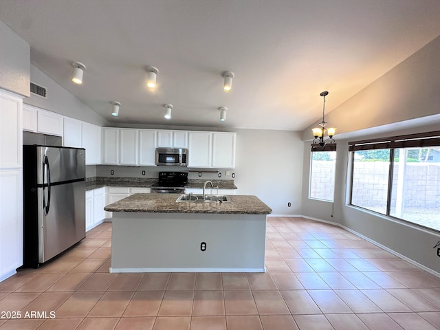 kitchen featuring light tile patterned floors, white cabinets, stainless steel appliances, and an island with sink