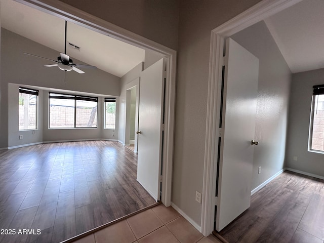 corridor with vaulted ceiling and light hardwood / wood-style flooring