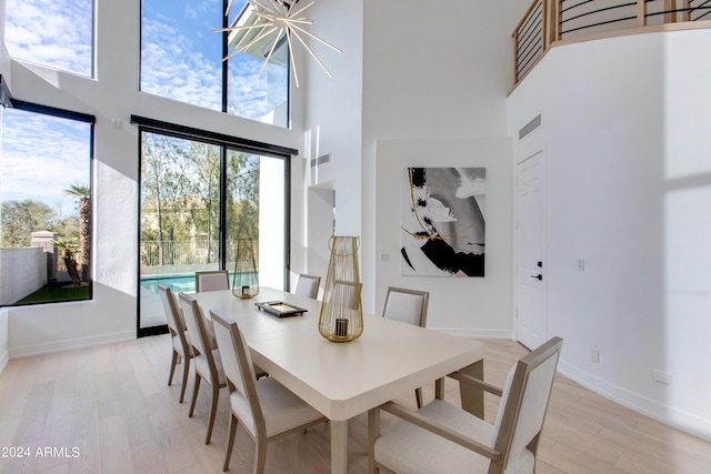 dining space featuring a high ceiling and light hardwood / wood-style flooring