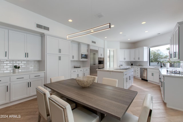 dining space with light wood-type flooring and sink