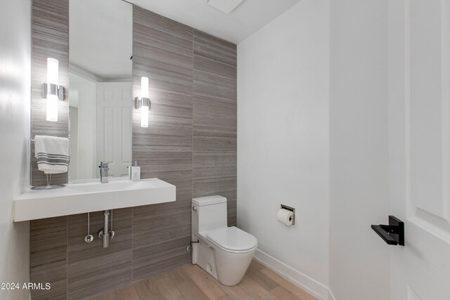 washroom with sink, cabinets, separate washer and dryer, and light wood-type flooring