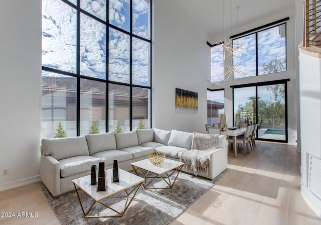 living room featuring a high ceiling, a wealth of natural light, and hardwood / wood-style floors