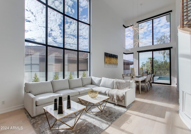 living room with a towering ceiling and wood-type flooring