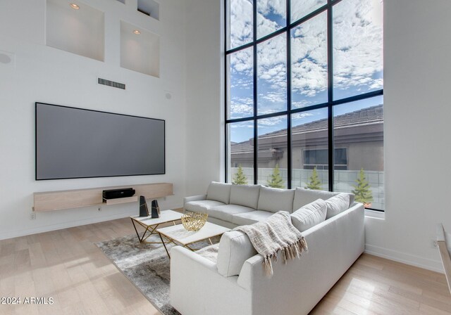 dining space featuring light hardwood / wood-style floors and a high ceiling