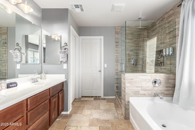 bathroom featuring vanity and independent shower and bath