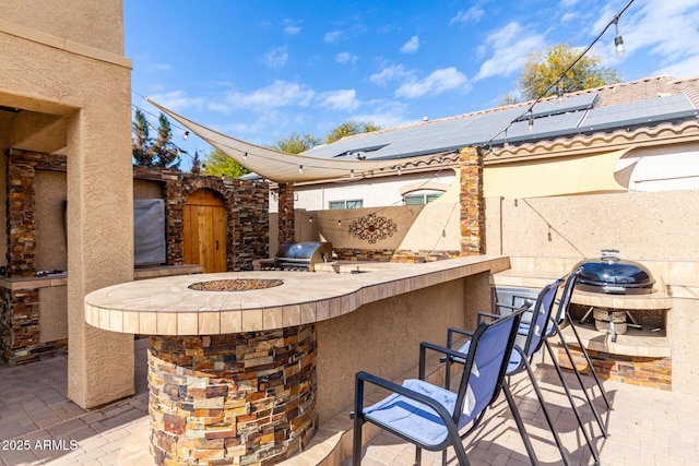 view of patio featuring exterior kitchen, area for grilling, and an outdoor bar