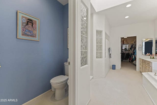 full bath with recessed lighting, a spacious closet, toilet, and vanity