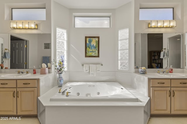 full bathroom featuring plenty of natural light, a jetted tub, two vanities, and a sink