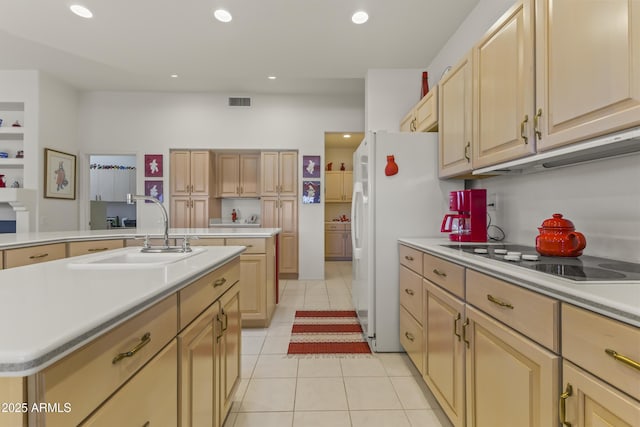 kitchen featuring white appliances, a kitchen island with sink, light countertops, a sink, and light tile patterned flooring