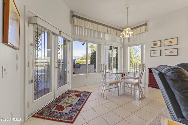 dining room with light tile patterned floors and an inviting chandelier