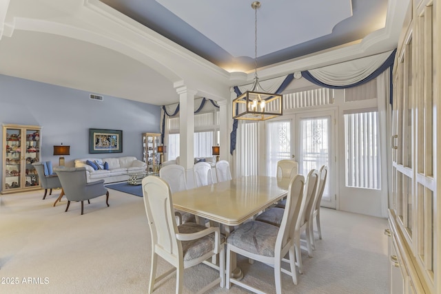 dining area with a notable chandelier, light carpet, visible vents, french doors, and a tray ceiling