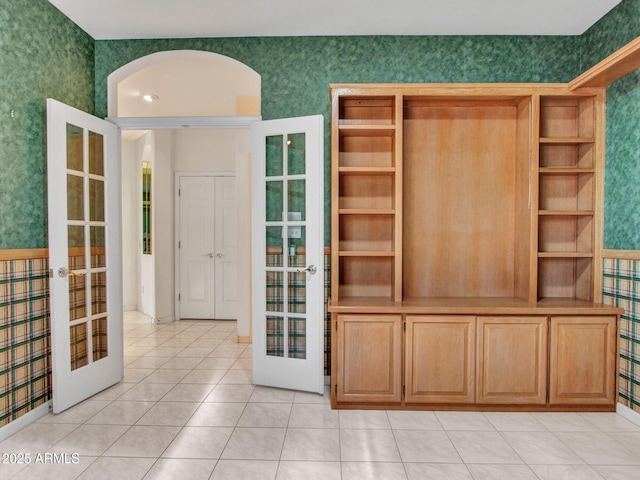 15377 W Catalina Ct, Goodyear, AZ 85395 - interior space with french doors, wallpapered walls, light tile patterned flooring, and arched walkways