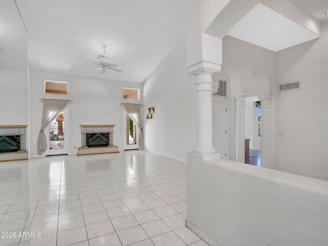 15377 W Catalina Ct, Goodyear, AZ 85395 - unfurnished living room featuring a fireplace with raised hearth, ceiling fan, light tile patterned floors, and a high ceiling